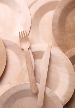 Beyaz arka planda bir dizi ahşap eko tabak. Tabaklar, çatal ve bıçak.