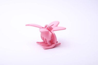 Beyaz arka plan üzerinde pembe plastik saç tokası