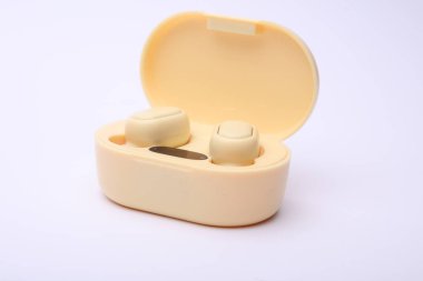 Kablosuz kulaklıklar ve beyaz arka planda şarj davası