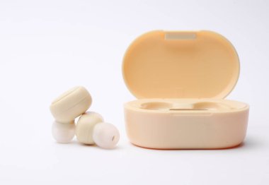 Kablosuz kulaklıklar ve beyaz arka planda şarj davası