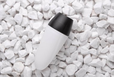 Beyaz terleme önleyici çubuk tüpü çakıl taşlarına yakın.