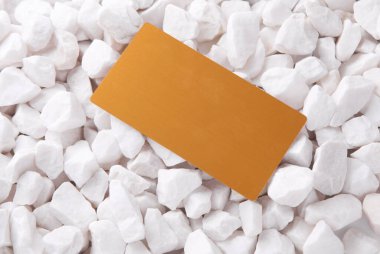 Beyaz çakıl taşları üzerinde altın kartvizit