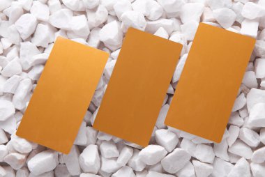 Beyaz çakıl taşları üzerinde altın kartvizitler