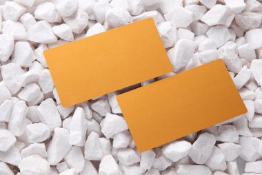 Beyaz çakıl taşları üzerinde altın kartvizitler