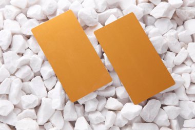 Beyaz çakıl taşları üzerinde altın kartvizitler