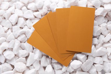 Beyaz çakıl taşları üzerinde altın kartvizitler