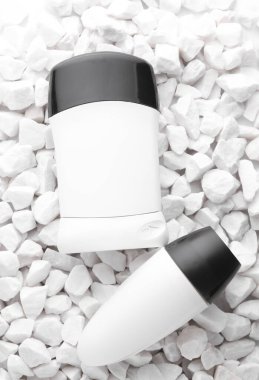 Beyaz terleme önleyici çubuk tüpleri çakıl taşlarına yakın.