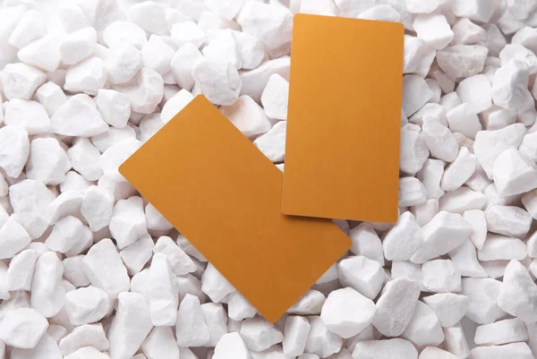 Beyaz çakıl taşları üzerinde altın kartvizitler