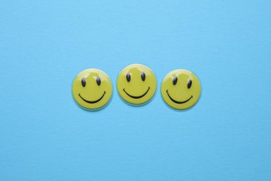 ODESSA, UKRAINE - 25 Ağustos 2023: Mavi arka planda gülümseyen sarı simgeler