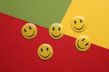 ODESSA, UKRAINE - 25 Ağustos 2023: Renkli arka planda gülümseyen sarı simgeler