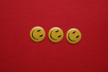 ODESSA, UKRAINE - 25 Ağustos 2023: Kırmızı arka planda gülümseyen sarı simgeler