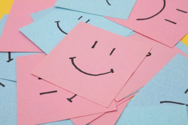 Kare kağıtlarda mutlu ve mutsuz yüzler