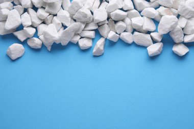 Mavi arka planda beyaz çakıl taşları. Boşluğu kopyala