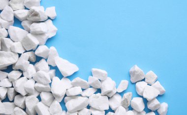 Mavi arka planda beyaz çakıl taşları. Boşluğu kopyala