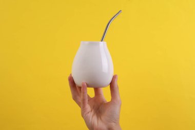 Dişi el, sarı arka planda beyaz kabaklı bombilla tutuyor. Tasarım için model