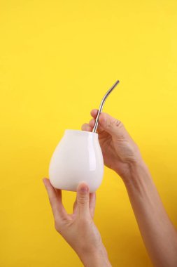 Dişi el, sarı arka planda beyaz kabaklı bombilla tutuyor. Tasarım için model