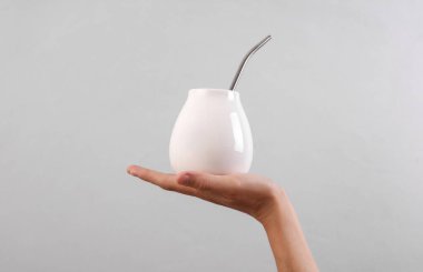 Gri arka planda beyaz kabaklı kadın el bombilla tutuyor. Tasarım için model