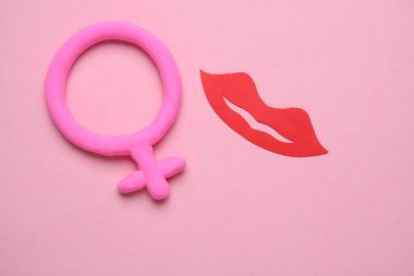Pembe arka planda kadın cinsiyet sembolü ve dudaklar