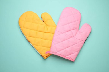 Mavi arka planda pişirmek için mutfak eldivenleri