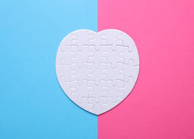 Pembe mavi arka planda beyaz, boş kalp şeklinde bir yapboz. Tasarım için model