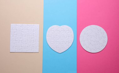 Renkli arkaplanda farklı şekillerde beyaz boş yapboz yap-bozları