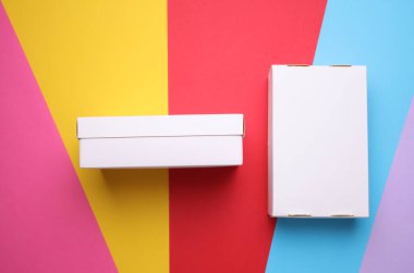 Renkli arkaplanda beyaz karton kutular