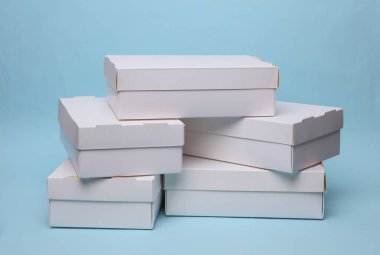 Mavi zemin üzerinde beyaz karton kutular yığını