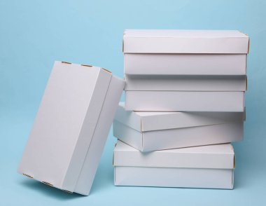 Mavi zemin üzerinde beyaz karton kutular yığını