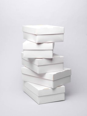 Gri zemin üzerinde beyaz karton kutular yığını