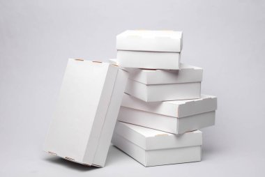 Gri zemin üzerinde beyaz karton kutular yığını