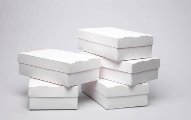 Gri zemin üzerinde beyaz karton kutular yığını