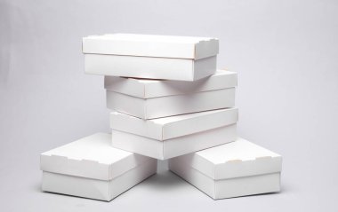 Gri zemin üzerinde beyaz karton kutular yığını