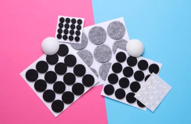 Pembe mavi arka planda mobilyalar için koruyucu daire pedleri hissettim.