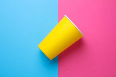 Pembe Mavi Arkaplanda Sıcak İçecekler İçin Sarı Tek Kullanılabilir Bardaklar. Üst Görünüm