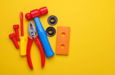 Sarı arka planda bir grup çocuk oyuncağı. Düz yatıyordu