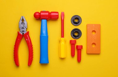 Sarı arka planda bir grup çocuk oyuncağı. Düz yatıyordu