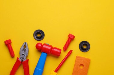 Sarı arka planda bir grup çocuk oyuncağı. Düz yatıyordu