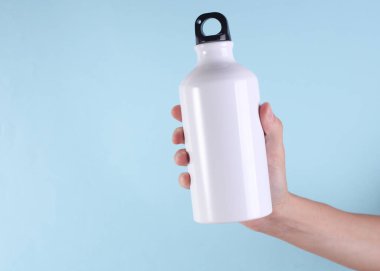 Beyaz metal su şişesi, mavi arka planda termos şişesi. Tasarım için model