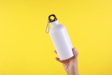 Beyaz metal su şişesi, sarı arka planda termos şişesi. Tasarım için model