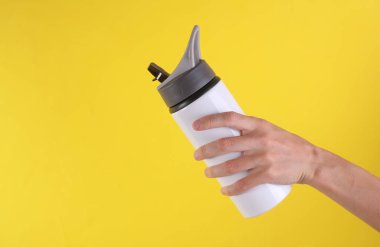 Beyaz metal su şişesi, sarı arka planda termos şişesi. Tasarım için model