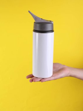 Beyaz metal su şişesi, sarı arka planda termos şişesi. Tasarım için model