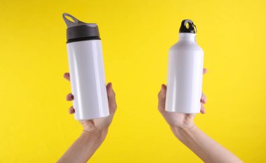 Beyaz metal su şişeleri, sarı arka planda termos şişeleri. Tasarım için model