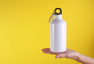 Beyaz metal su şişesi, sarı arka planda termos şişesi. Tasarım için model