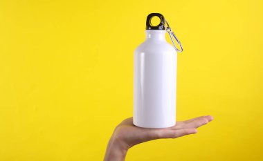 Beyaz metal su şişesi, sarı arka planda termos şişesi. Tasarım için model