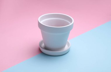 Pembe arka planda beyaz, boş, kilden bir saksı. Tasarım için model