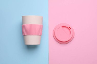 Mavi arka planda sıcak içecekler için yeniden kullanılabilir plastik bardak. Üst görünüm