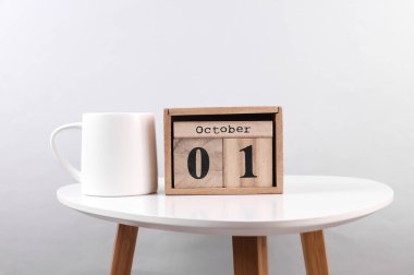 Wooden calendar organizer with date october 01 on table