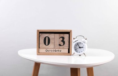 Ekim 03 tarihli ahşap takvim düzenleyici ve masada çalar saat