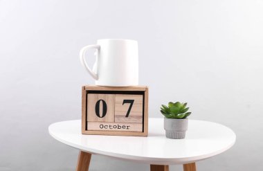 Ekim 07 tarihli ahşap takvim düzenleyici ve masa üzerinde dekoratif bitki