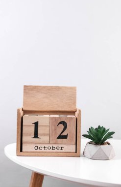 Tahta takvim düzenleyicisi. Masada 12 Ekim 'e ait dekoratif bitki tarihi var.